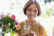© Tom Merton/Caia Image - Portrait smiling, confident senior woman drinking tea next to flower bouquet