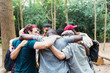 © Tom Merton/Caia Image - Men friends hugging in huddle on hike in woods