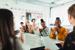 © Paul Bradbury/Caia Image - Happy high school students clapping in debate class