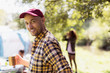 © Sam Edwards/Caia Image - Portrait happy man drinking coffee at sunny campsite