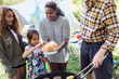 © Sam Edwards/Caia Image - Family barbecuing hamburgers at campsite