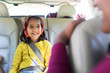 © Sam Edwards/Caia Image - Smiling girl with headphones riding in back seat of car