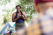 © Sam Edwards/Caia Image - Happy woman with camera at campsite