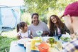 © Sam Edwards/Caia Image - Happy family enjoying lunch at campsite table