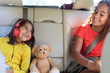 © Sam Edwards/Caia Image - Happy sisters and teddy bear riding in back seat of car
