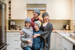 © Jarusha Brown/Caia Image - Portrait silly family making faces in kitchen
