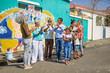 © Trevor Adeline/Caia Image - Happy community volunteers celebrating painted mural on sunny urban wall