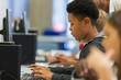 © Paul Bradbury/Caia Image - Focused junior high boy student using computer in computer lab