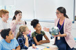 © Robert Daly/Caia Image - Attentive junior high school students watching geography teacher globe
