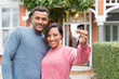 © Robert Daly/Caia Image - Portrait happy couple with house keys outside new house
