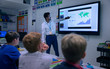 © Robert Daly/Caia Image - Teacher leading lesson at touch screen in classroom