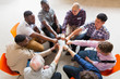 © Tom Merton/Caia Image - Men joining fists in circle in group therapy