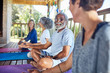 © Trevor Adeline/Caia Image - Senior man talking with woman in hut during yoga retreat