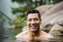 Portrait Smiling, Handsome Young Man Swimming In Lake