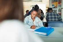 High School Girl Student Doing Homework At Table In Classroom