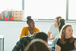 © Paul Bradbury/Caia Image - High school girl students talking, doing homework in classroom