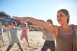 © Trevor Adeline/Caia Image - Confident woman practicing warrior 2 pose on sunny beach during yoga retreat