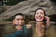 © Jarusha Brown/Caia Image - Portrait playful young couple swimming in lake