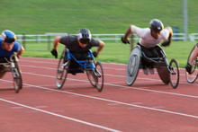 Determined Paraplegic Athlete Speeding Along Sports Track In Wheelchair Race