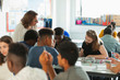 © Paul Bradbury/Caia Image - High school teacher helping students studying in classroom