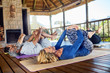 © Trevor Adeline/Caia Image - Yoga class stretching in hut during yoga retreat