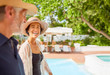 © Trevor Adeline/Caia Image - Happy mature couple at sunny resort poolside