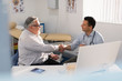 © Tom Merton/Caia Image - Male doctor shaking hands with senior patient in doctors office