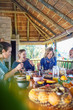© Trevor Adeline/Caia Image - Friends enjoying healthy meal in hut during yoga retreat