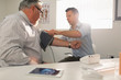 © Tom Merton/Caia Image - Male doctor checking blood pressure of senior patient in doctors office