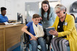 © Tom Merton/Caia Image - Female doctor with digital tablet talking to mother and boy patient in wheelchair in clinic lobby