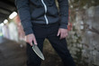 © Tom Merton/Caia Image - Young man holding knife weapon in tunnel