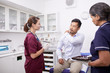 © Trevor Adeline/Caia Image - Male patient explaining shoulder pain to female doctor in clinic examination room