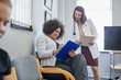 © Trevor Adeline/Caia Image - Female doctor and patient discussing paperwork in clinic waiting room