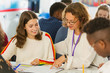 © Chris Ryan/Caia Image - Female high school teacher helping girl student with homework in classroom