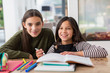 © Chris Ryan/Caia Image - Portrait happy sisters coloring, doing homework