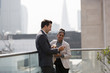 © Tom Merton/Caia Image - Business people talking on sunny, urban balcony