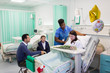 © Tom Merton/Caia Image - Nurse adjusting pillows for patient in hospital ward