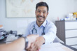 © Trevor Adeline/Caia Image - Point of view happy doctor shaking hands with patient