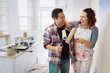 © Robert Daly/Caia Image - Happy, playful couple with paint rollers painting room