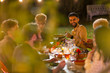 © Paul Bradbury/Caia Image - Happy friends enjoying dinner garden party