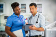 © Chris Ryan/Caia Image - Male doctor with digital tablet talking with female nurse in hospital