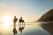 © Trevor Adeline/Caia Image - Young women horseback riding in tranquil ocean surf at sunset