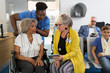 © Tom Merton/Caia Image - Female doctor with digital tablet talking to senior patient in wheelchair in clinic lobby