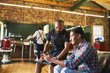 © Trevor Adeline/Caia Image - Male barber and customer with digital tablet in barbershop