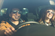 © Tom Merton/Caia Image - Happy young couple wearing sunglasses in car
