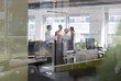 © Martin Barraud/Caia Image - Business people talking, meeting in open plan office