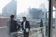 © Tom Merton/Caia Image - Businessmen talking on sunny, urban highrise office balcony