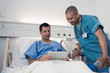 © Sam Edwards/Caia Image - Male patient with digital tablet talking to nurse in hospital room