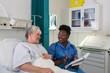 © Tom Merton/Caia Image - Female nurse talking with senior patient in hospital room