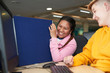 © Himalayan Pics/Caia Image - Happy young female college students laughing at computer in library